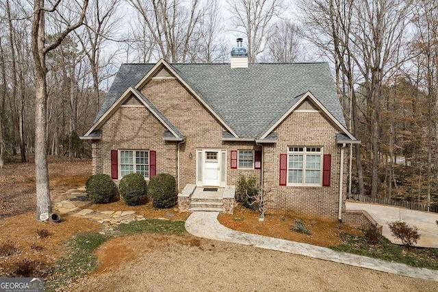 craftsman-style home with brick siding, a chimney, and roof with shingles