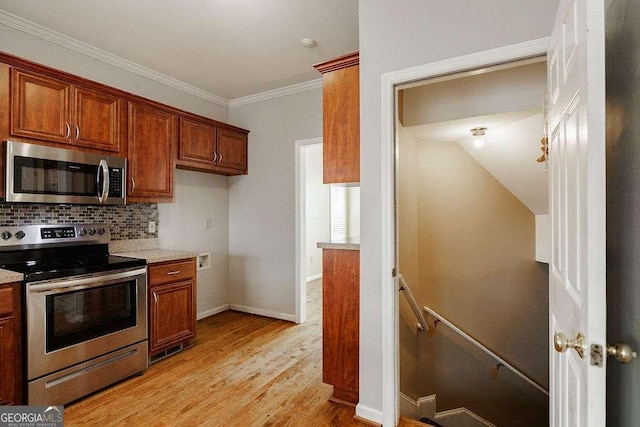 kitchen featuring light wood finished floors, appliances with stainless steel finishes, brown cabinetry, and backsplash