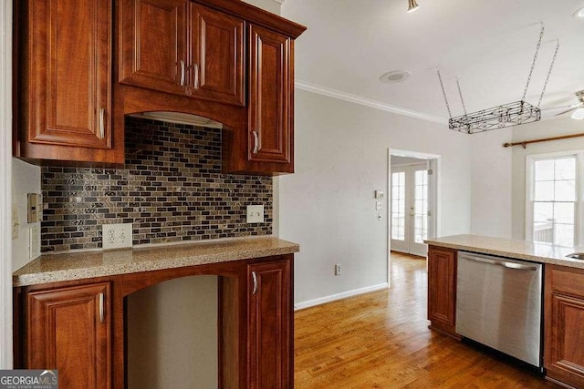 kitchen featuring light wood finished floors, stainless steel dishwasher, crown molding, baseboards, and tasteful backsplash