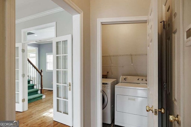 washroom featuring washer and dryer, laundry area, crown molding, and light wood-style flooring