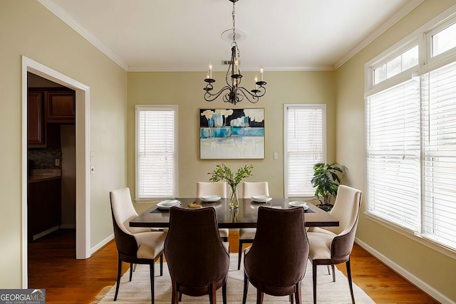 dining room featuring a chandelier, light wood finished floors, and ornamental molding