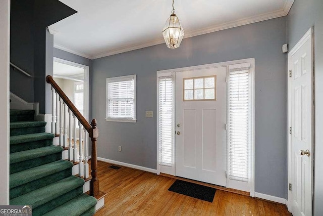 foyer featuring light wood-type flooring, baseboards, visible vents, a chandelier, and stairway