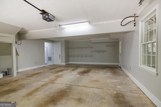 garage featuring visible vents, baseboards, and a garage door opener