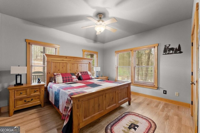 bedroom featuring baseboards, ceiling fan, and light wood-style flooring