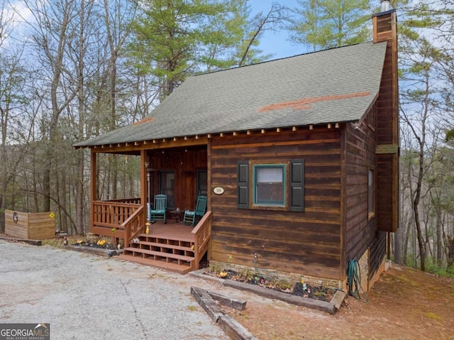 view of front of home featuring a shingled roof and a chimney