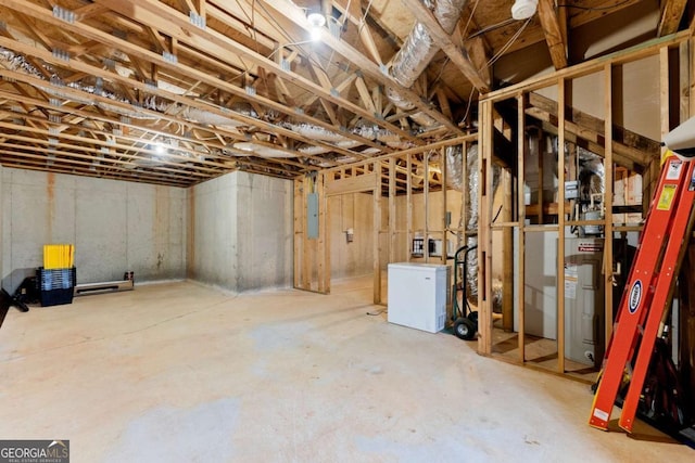 unfinished basement featuring fridge and electric panel