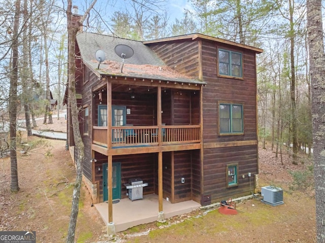 exterior space featuring a patio, roof with shingles, central AC, and a wooden deck