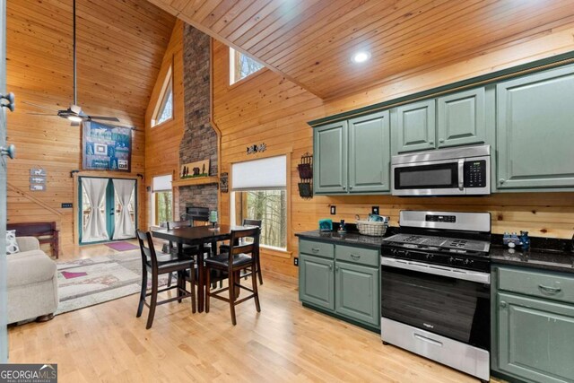 living room featuring a high ceiling, wood walls, a ceiling fan, wood ceiling, and light wood-style floors