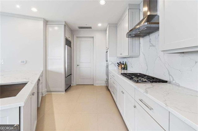 kitchen with stainless steel appliances, recessed lighting, tasteful backsplash, a sink, and wall chimney range hood