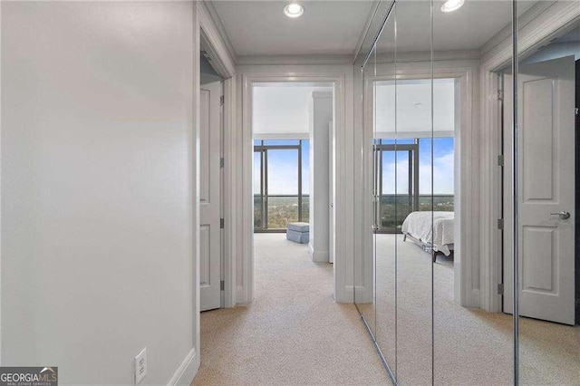 hallway with recessed lighting, light carpet, and baseboards