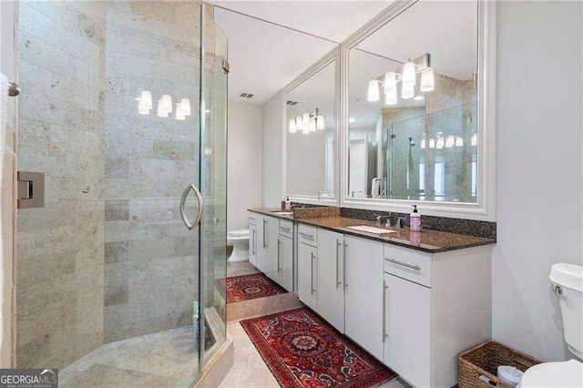 bathroom with toilet, a shower stall, visible vents, and vanity