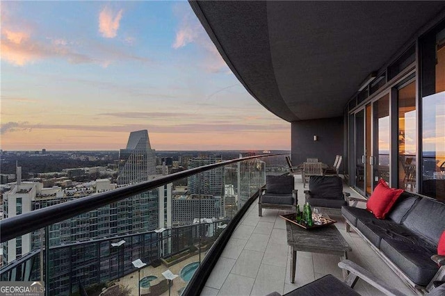 balcony at dusk with a view of city and an outdoor living space