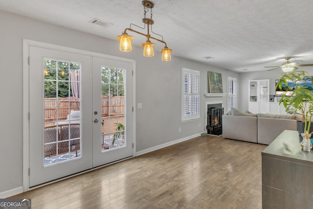 doorway to outside with french doors, a textured ceiling, and wood finished floors