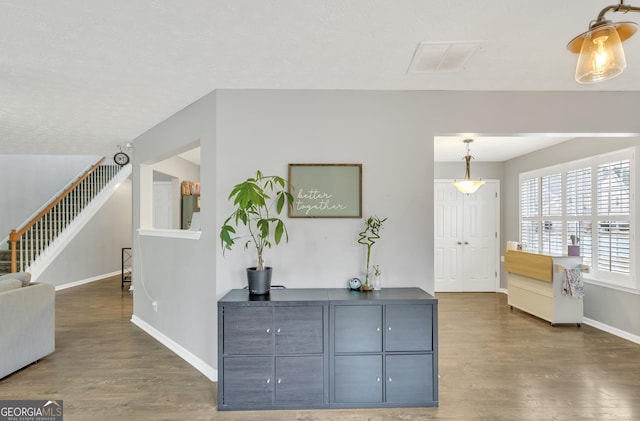 interior space with visible vents, stairs, baseboards, and wood finished floors