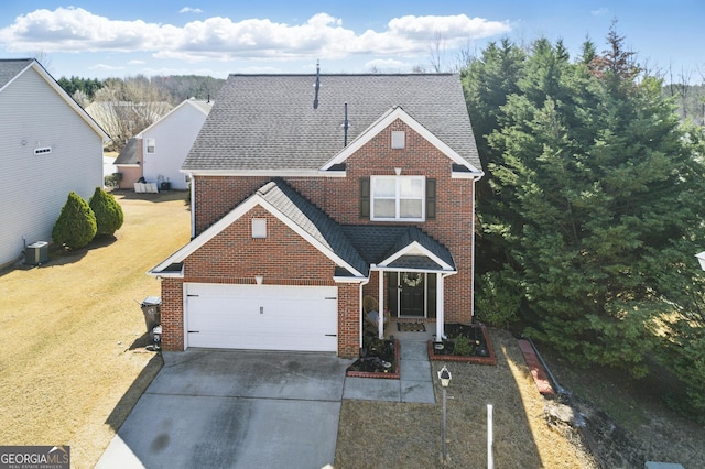 traditional home with brick siding, a front lawn, concrete driveway, and roof with shingles