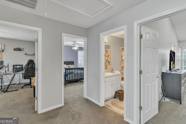 hallway with carpet flooring, baseboards, visible vents, and a wealth of natural light