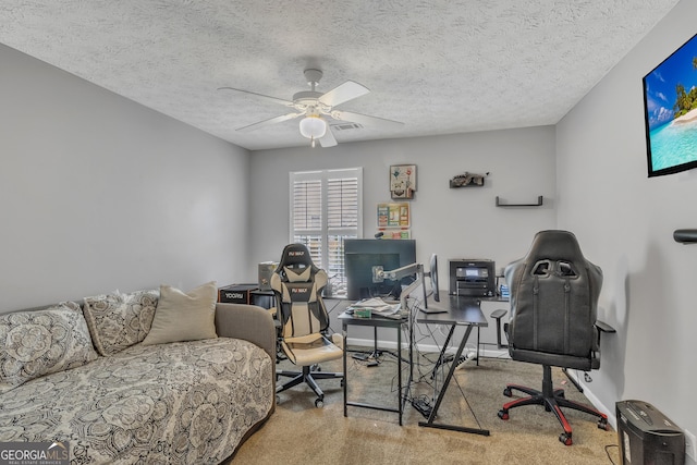 carpeted office space featuring a ceiling fan, baseboards, and a textured ceiling