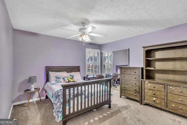 carpeted bedroom featuring baseboards, a textured ceiling, and a ceiling fan