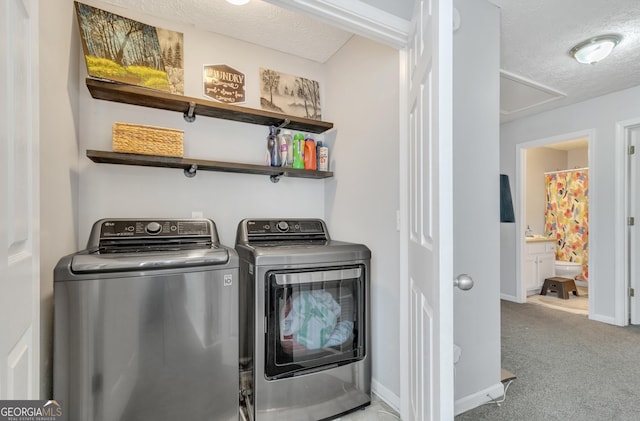 washroom featuring baseboards, carpet floors, laundry area, a textured ceiling, and washer and dryer