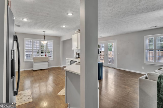 kitchen with french doors, stainless steel fridge, dark wood-style floors, and light countertops