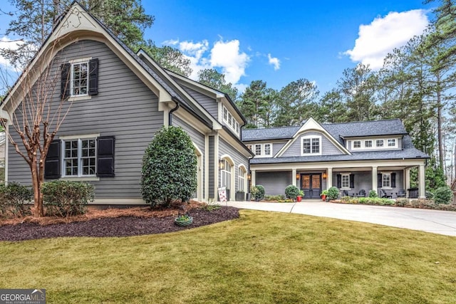 view of front facade with driveway, a garage, a porch, and a front yard