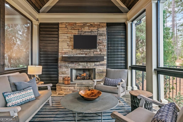 sunroom with an outdoor stone fireplace