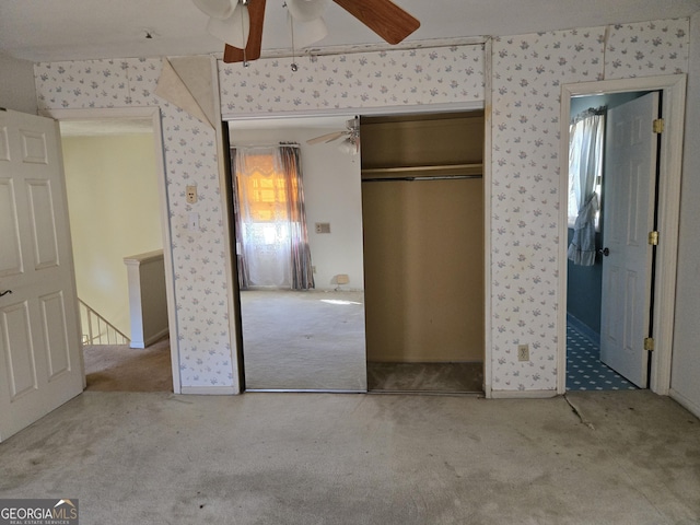 unfurnished bedroom featuring ceiling fan, a closet, and carpet