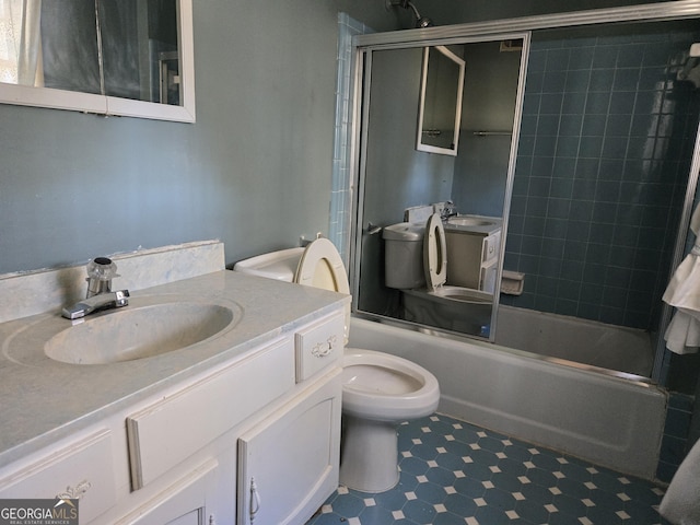 bathroom featuring tile patterned floors, vanity, toilet, and bath / shower combo with glass door