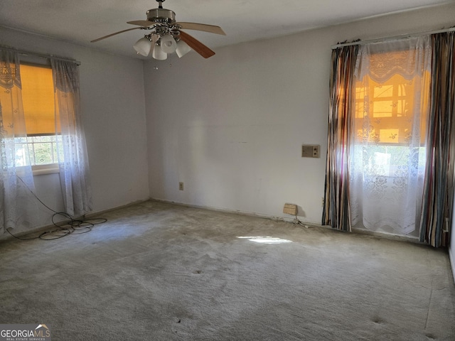 carpeted spare room featuring a ceiling fan