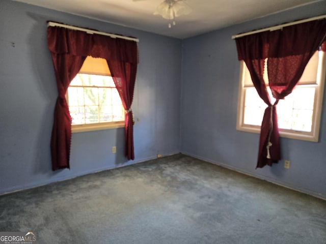 carpeted spare room with a ceiling fan and a wealth of natural light