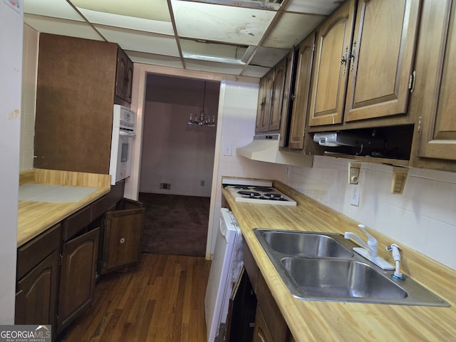 kitchen with white appliances, butcher block countertops, decorative backsplash, and a sink