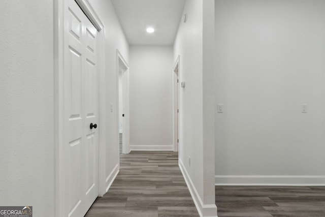 hall featuring dark wood finished floors, recessed lighting, and baseboards