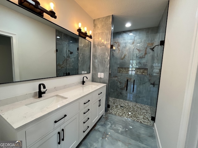 bathroom with a sink, a marble finish shower, marble finish floor, and double vanity