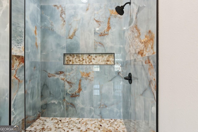 room details featuring a marble finish shower
