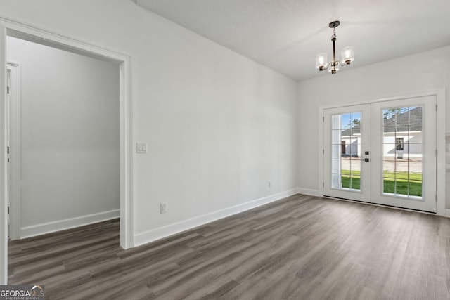 unfurnished room with dark wood-type flooring, french doors, baseboards, and a chandelier