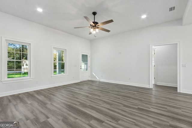 spare room with visible vents, baseboards, dark wood-style floors, and ceiling fan