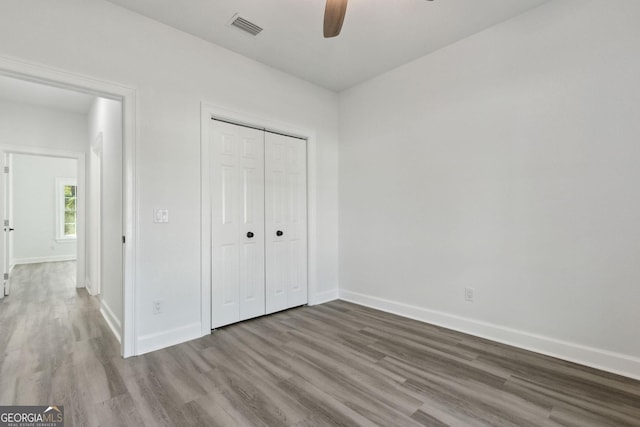 unfurnished bedroom with visible vents, baseboards, and wood finished floors