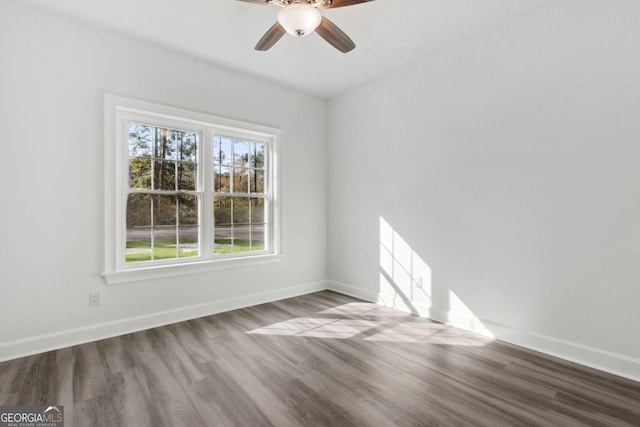 empty room with wood finished floors, baseboards, and ceiling fan