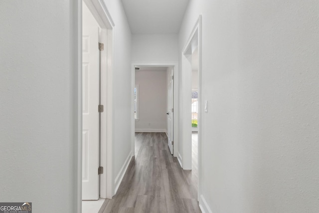hall featuring baseboards and wood finished floors