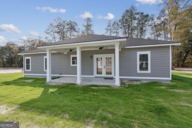 back of property with a patio, a ceiling fan, a yard, a shingled roof, and french doors