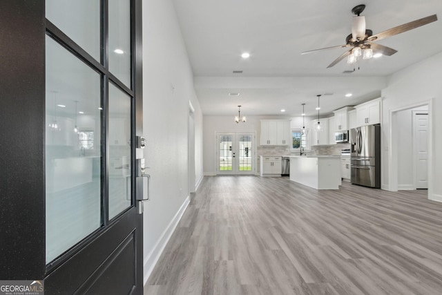 unfurnished living room with light wood finished floors, recessed lighting, a ceiling fan, and baseboards