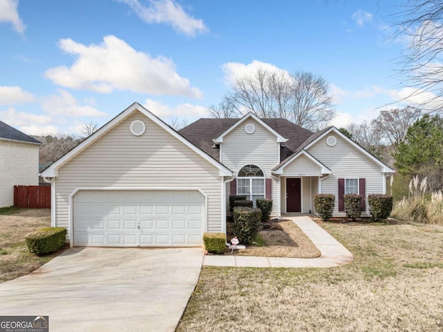 traditional-style home with a garage, a front yard, concrete driveway, and fence