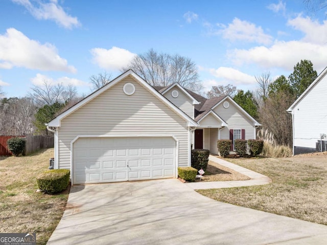 traditional-style home featuring driveway, an attached garage, fence, and a front lawn