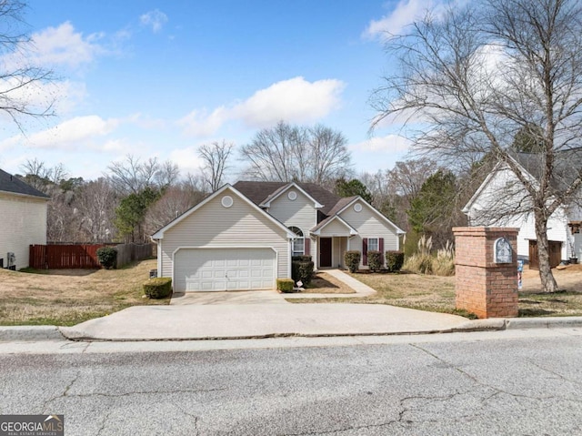 view of front facade featuring an attached garage, fence, a front lawn, and concrete driveway