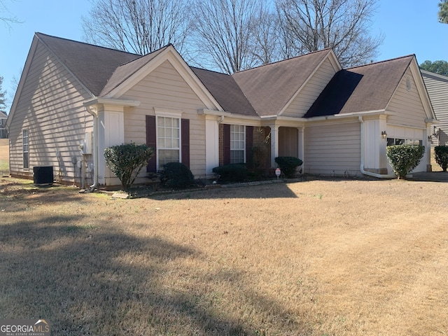 view of front of house with central AC unit, board and batten siding, an attached garage, and a front yard