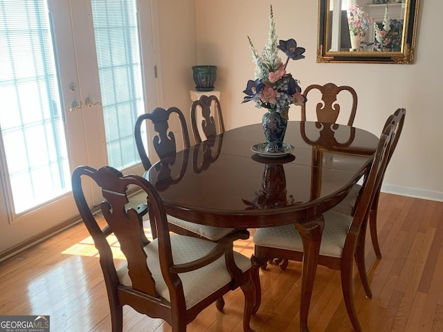 dining space with light wood-type flooring and baseboards