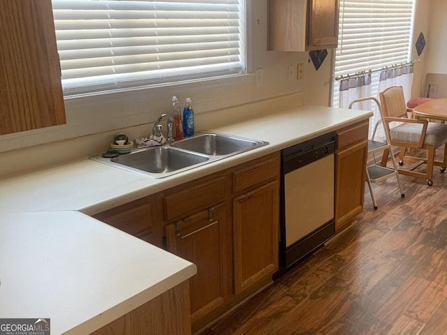 kitchen featuring dishwashing machine, dark wood-style flooring, a sink, and light countertops