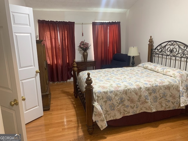 bedroom with light wood-style flooring and a textured ceiling