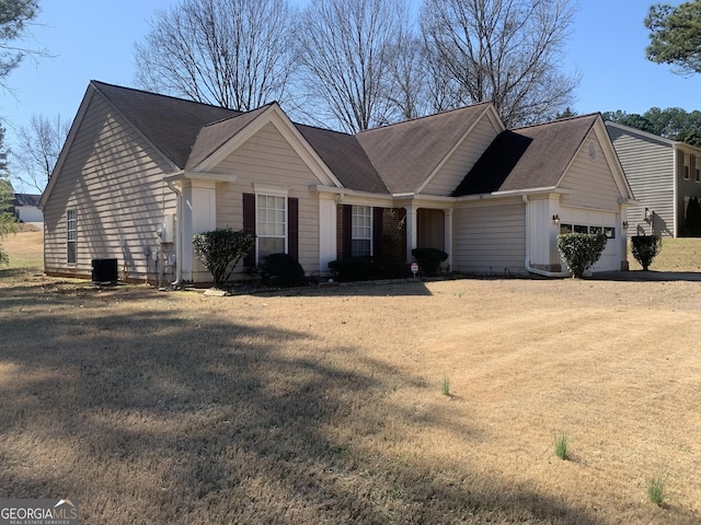 ranch-style house featuring a garage, driveway, central air condition unit, board and batten siding, and a front yard