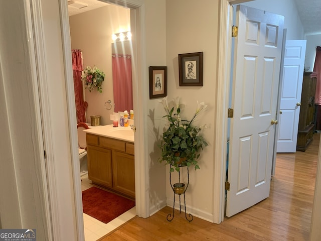 bathroom featuring baseboards, wood finished floors, and vanity